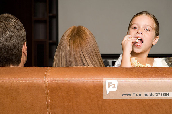 Mädchen essen Popcorn mit Familie