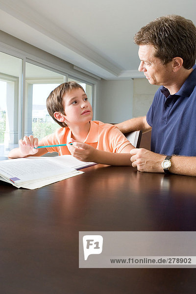 Vater hilft dem Sohn bei den Hausaufgaben