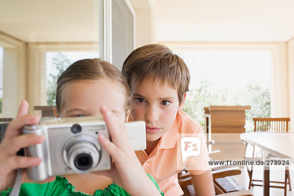 Brother and sister with digital camera
