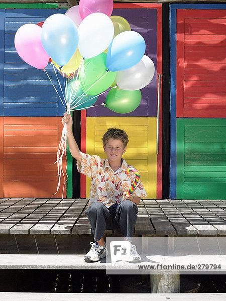 Boy on step with balloons