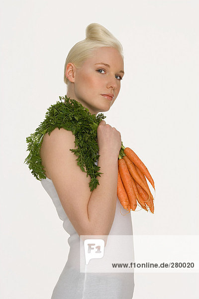 Junge Frau mit Karotten in der Hand