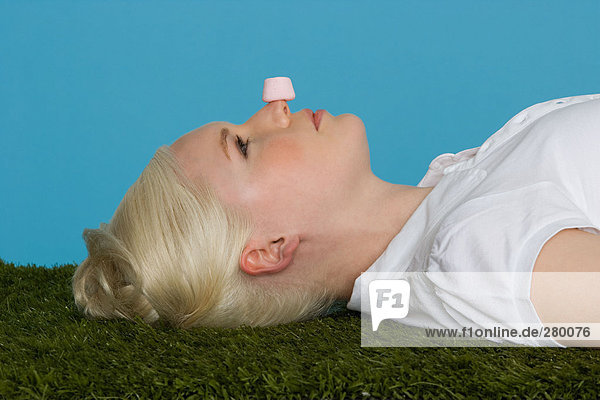 Junge Frau mit einem Marshmallow auf der Nase