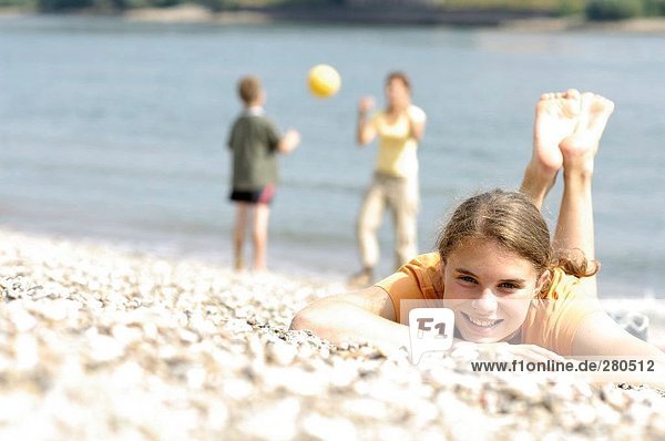 Teenagerin am Strand liegen und lächelnd portrait
