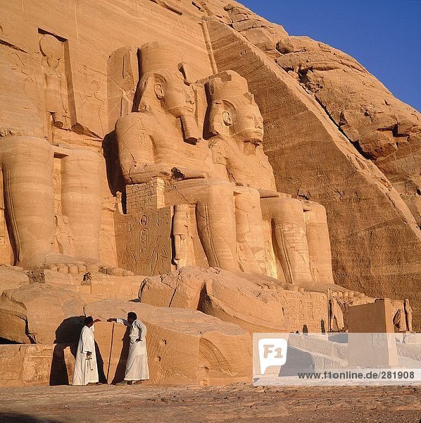 Two people at ancient Egyptian temple  Great Temple of Rameses II  Lake Nasser  Abu Simbel  Egypt