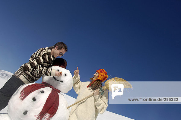 Junges Paar mit Schneemann
