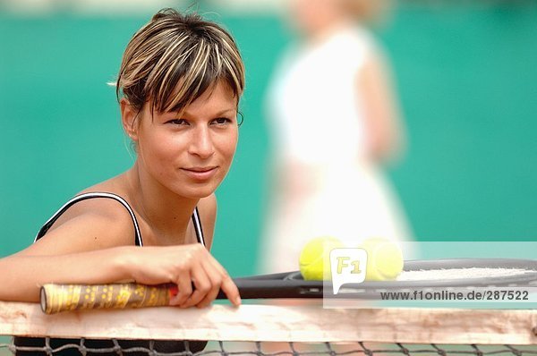 Weibliche Tennisspielerin stützte sich auf Net
