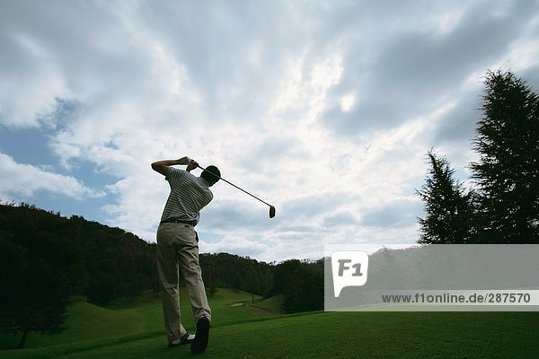 schaukeln schaukelnd schaukelt schwingen schwingt schwingend Mann Himmel dramatisch Golfsport Golf Verein