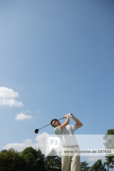 Junger Mann spielt Golf