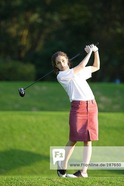 Junge Frau Golf zu spielen