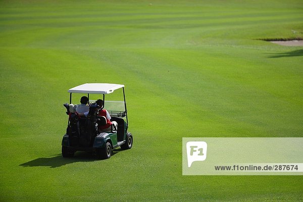 Paar fahren ein Golf-Cart auf einem Golfplatz