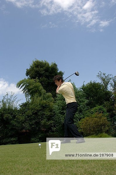 Side view of a man playing a golf shot