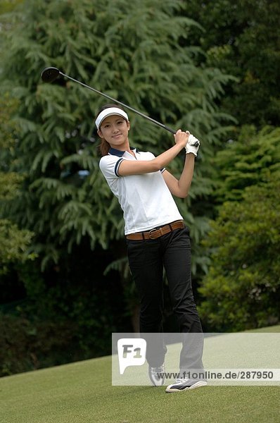 Front view of a woman playing a golf stroke