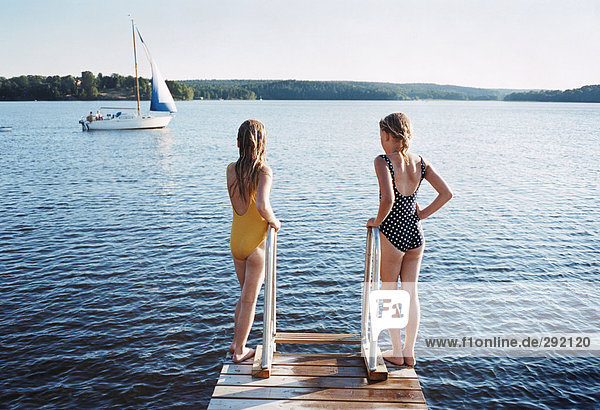 Zwei Mädchen auf einer Brücke.