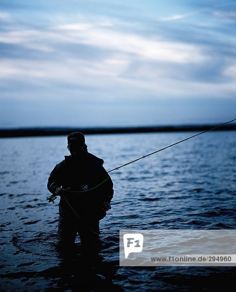 A man fishing in the sea.