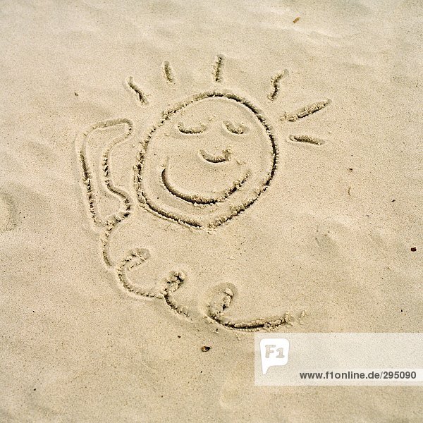 Eine Sonne und ein Telefon in Sand gezeichnet.