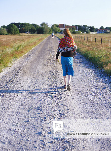 Eine Frau zu Fuß auf einer Landstraße Schweden.