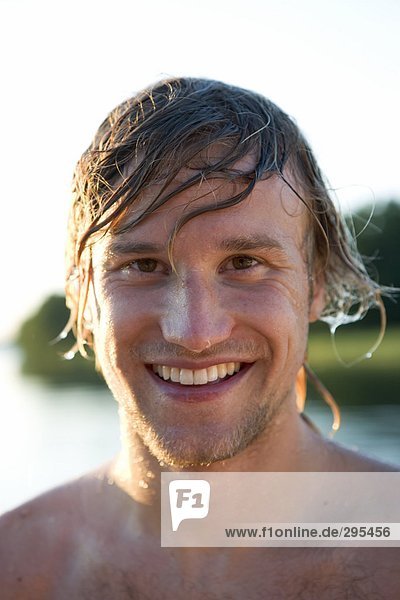 Ein lächelnd mann mit nasses Haar.