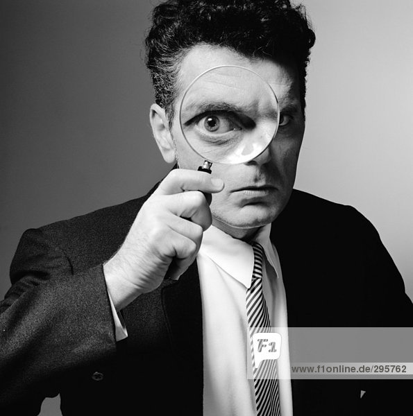 A man looking through a magnifying glass.