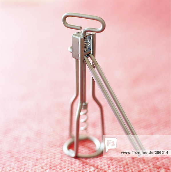 A corkscrew on a pink background.