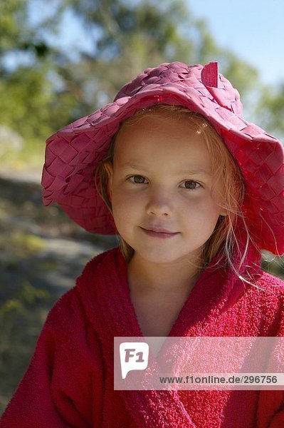 Portrait of a girl dressed in a bathrobe and sun hat.