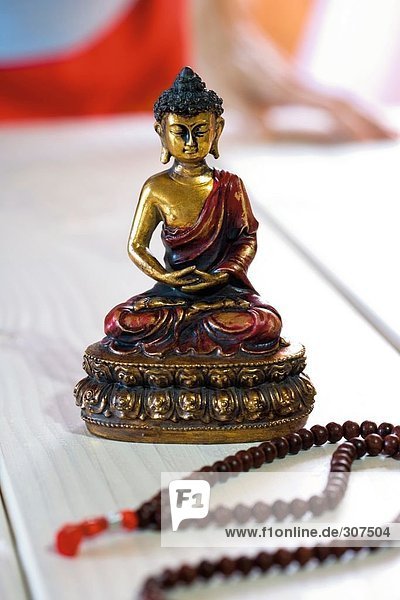 Nahaufnahme Gebetskette und Buddha-statue