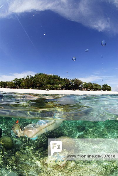 Philippinen  Dalmakya Island  Frau beim Schnorcheln im Meer  Unterwasserblick