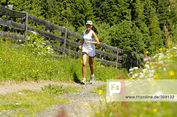 Young woman jogging in meadow  smiling