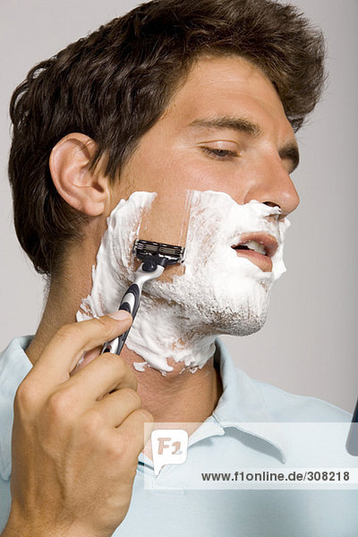Young man shaving  portrait