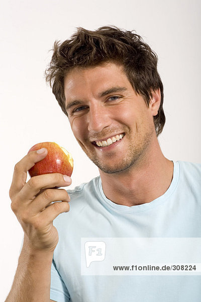 Junger Mann mit Apfel  Portrait  Nahaufnahme