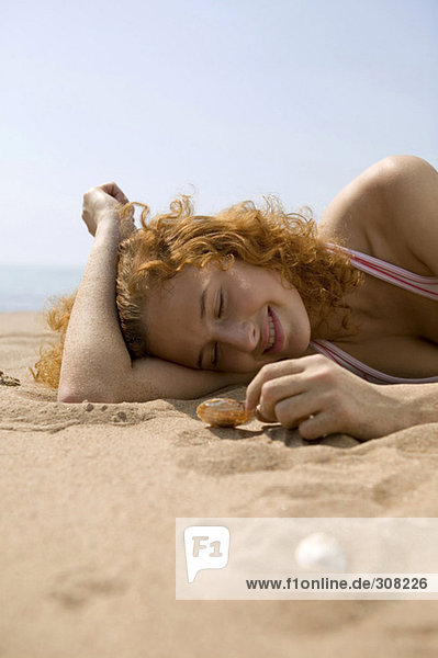 Junge Frau am Strand  mit Muschelschale