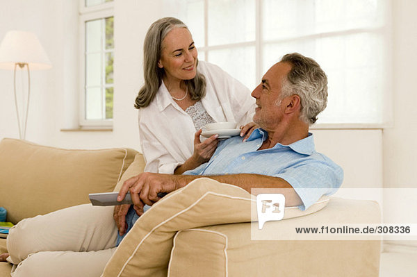Mature couple in living room  smiling  close-up
