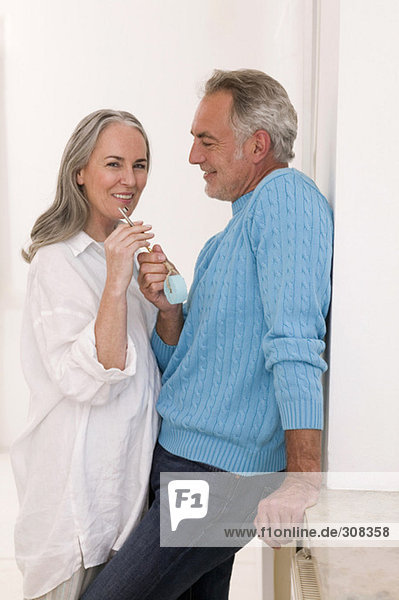 Erwachsenes Paar mit Schlüssel  lächelnd