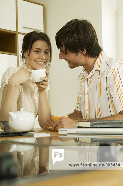 Junges Paar trinkt Tee in der Küche  lächelnd  Portrait