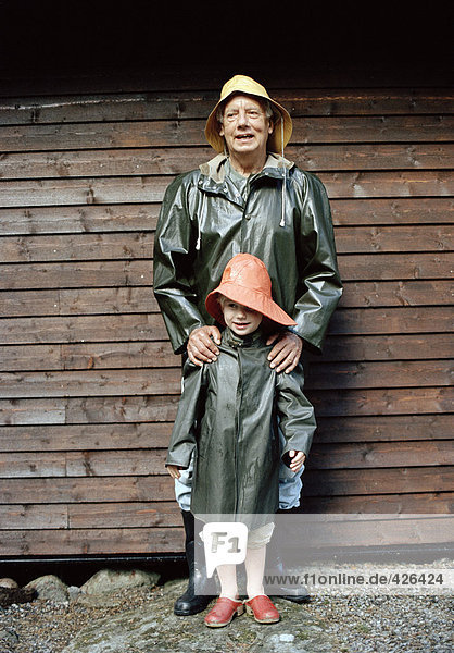 Portrait von Großvater und Enkelin in Regen Kleidung.