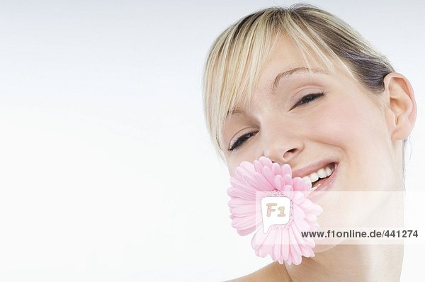 Young woman holding flower in mouth