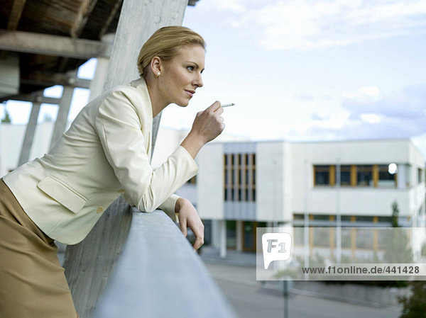 Geschäftsfrau raucht auf dem Balkon