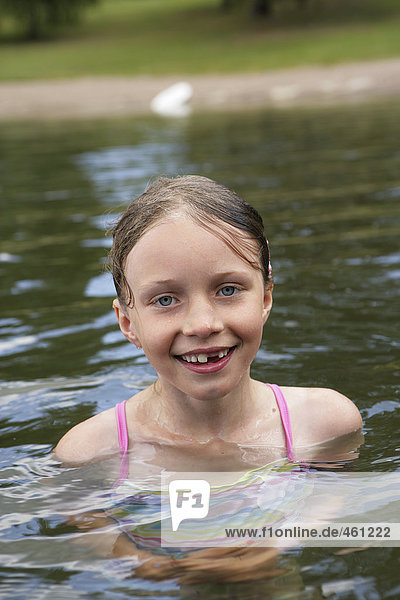 A smiling girl in a lake.
