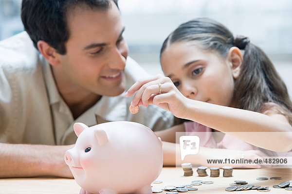 Father and daughter with piggy bank