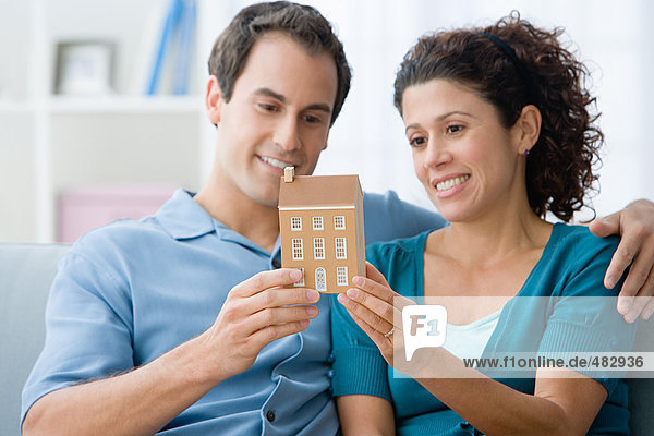 Couple holding a model of a house