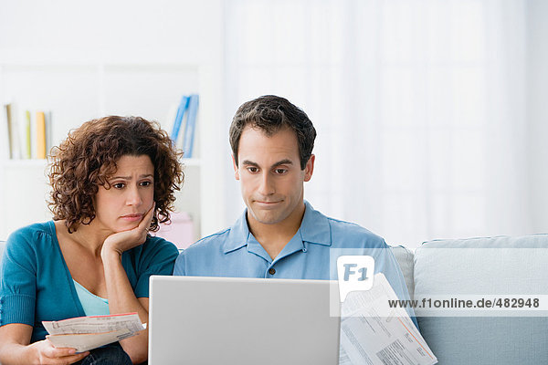 Couple looking at home finances on computer