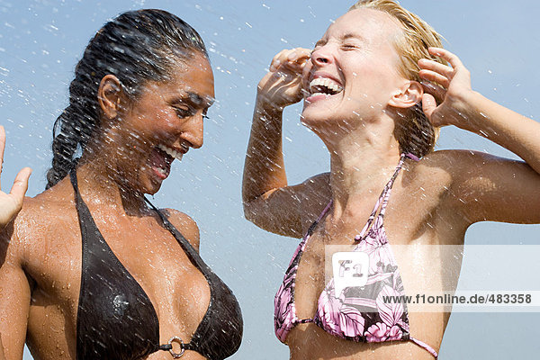 Zwei Frauen werden mit Wasser bespritzt.