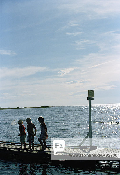 Three children on a jetty.
