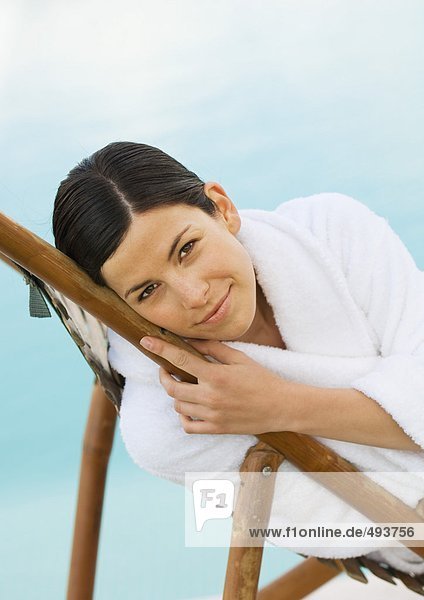 Woman in bathrobe reclining in lounge chair