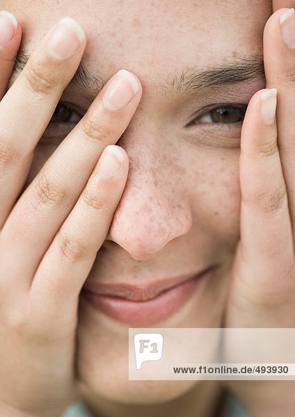 Frau schaut durch die Finger  extreme Nahaufnahme