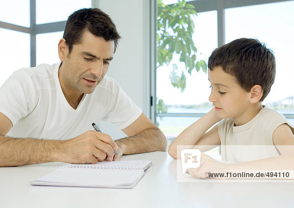 Mann hilft Sohn bei den Hausaufgaben