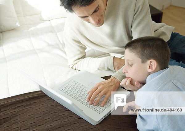 Mann und Sohn mit Laptop