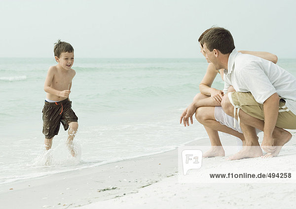Familie am Strand  Junge  dem das Wasser ausgeht.