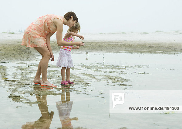 Mother and daughter on beach  full length