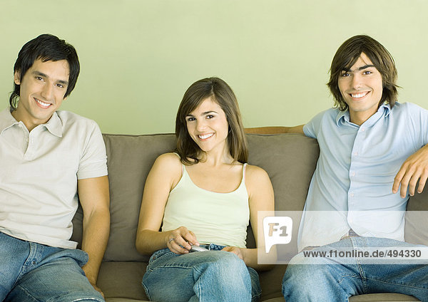 Gruppe junger erwachsener Freunde auf dem Sofa sitzend