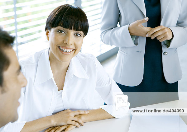 Businesswoman smiling  colleagues cropped